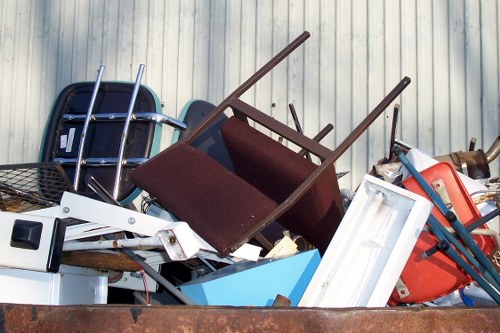 Insured waste removal van being loaded during house clearance